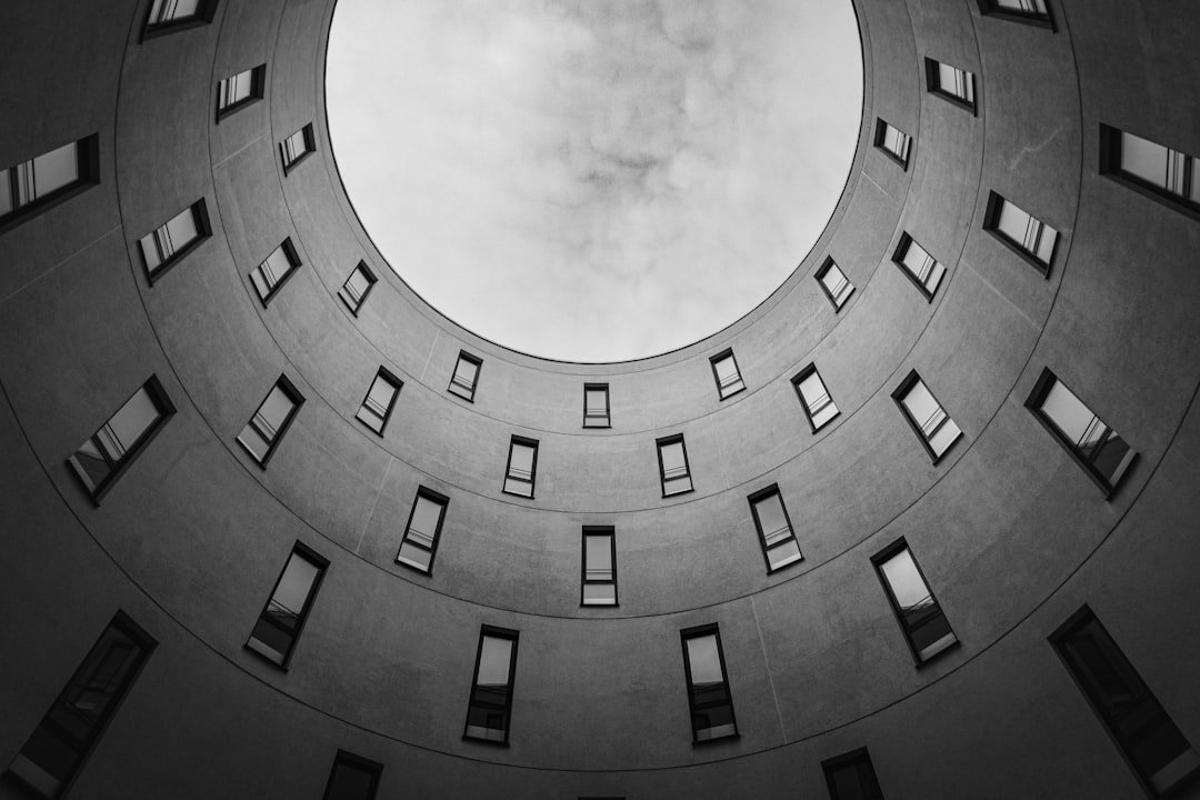 Services looking-up-at-a-circular-building-with-many-windows-v9g5zocok6s